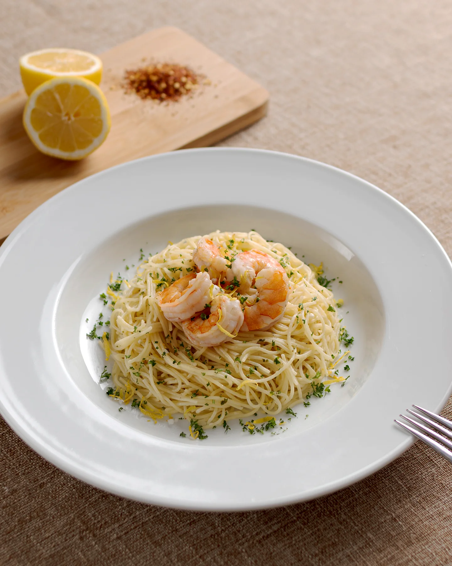 Plato de pasta con camarones acompañado de limón y chile seco, fotografía gastronómica estilo editorial tomada en Chihuahua.
