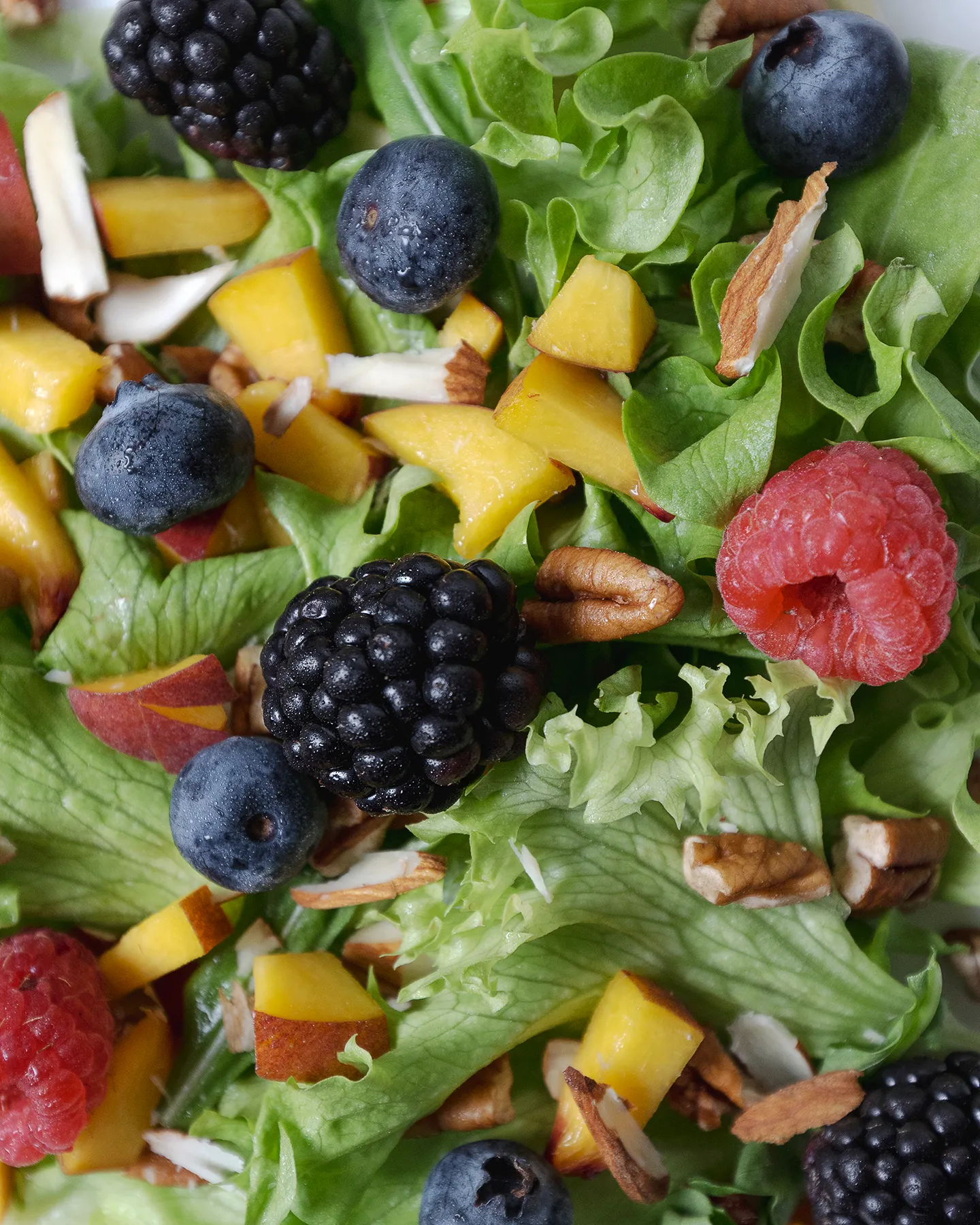 Fotografia en detalle de una ensalada con moras y duraznos