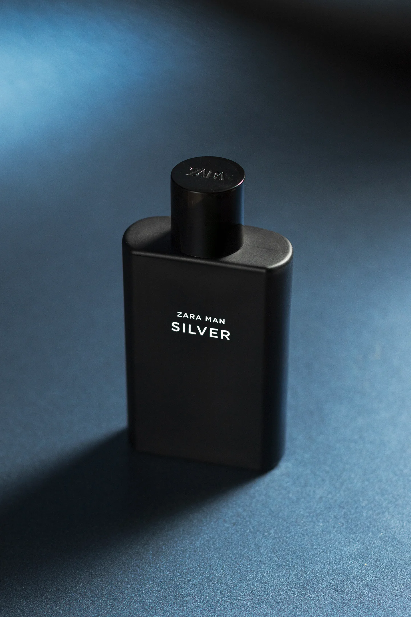 Fotografía de Producto de una botella negra de perfume de hombre.