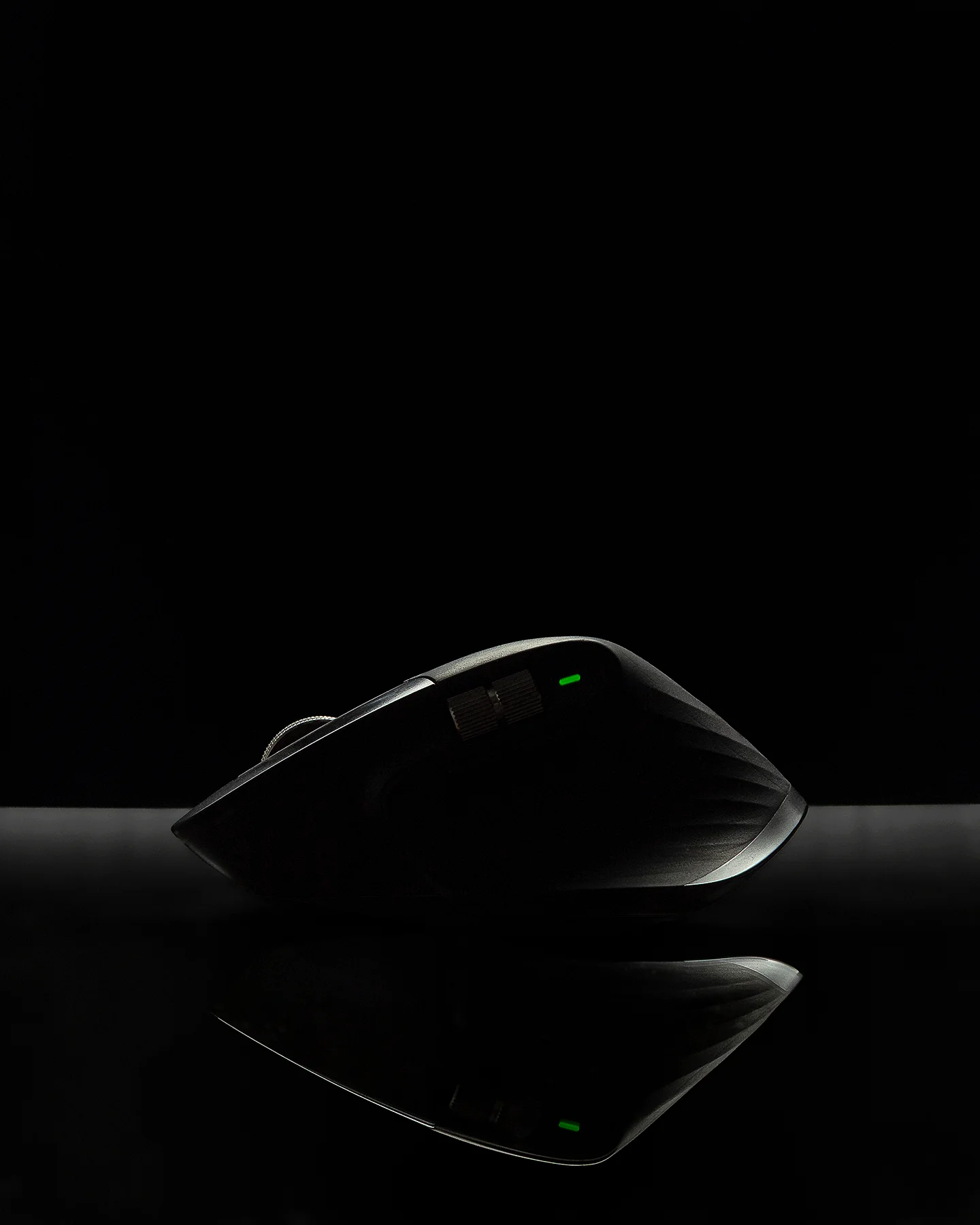 Fotografía creativa de producto con mouse iluminado y reflejo sobre fondo negro, estilo publicitario minimalista. Imagen para campañas de lanzamiento o revelación de producto, realizada por Andrés Gardea, fotógrafo de producto en Chihuahua.