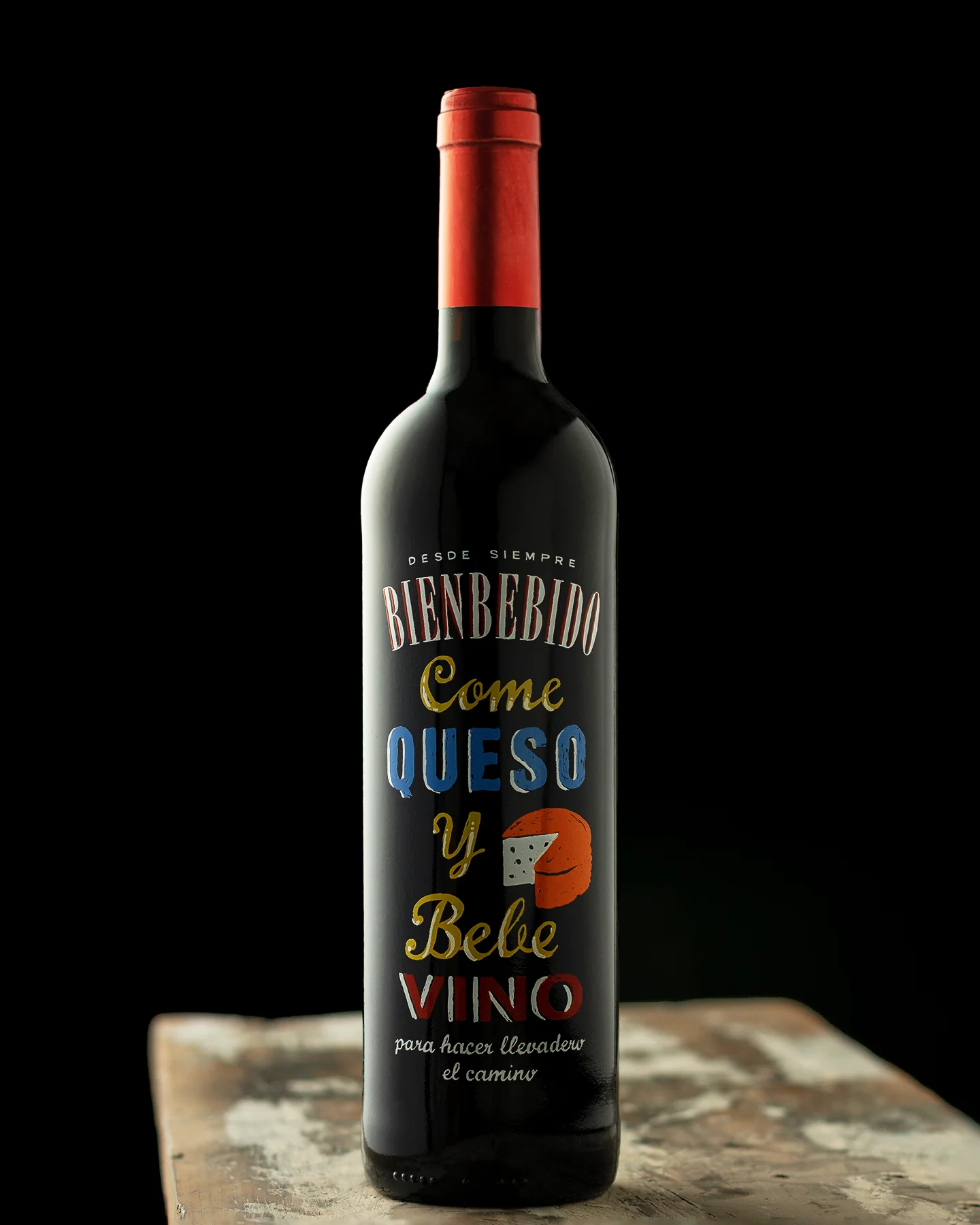 Fotografía profesional de botella de vino tinto aislada sobre fondo oscuro, con iluminación de estudio y enfoque en forma, etiqueta y branding del producto.