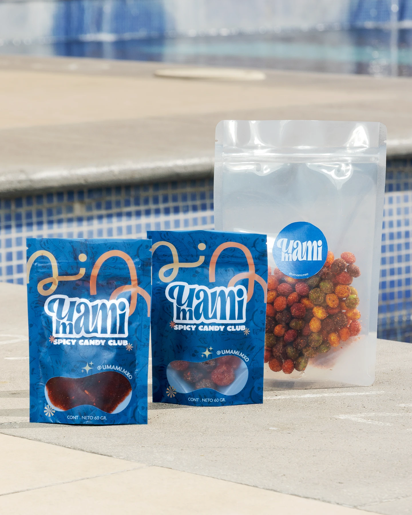 Fotografía de catálogo para marcas en Chihuahua: variedad de empaques de gomitas y dulces enchilados junto a alberca.