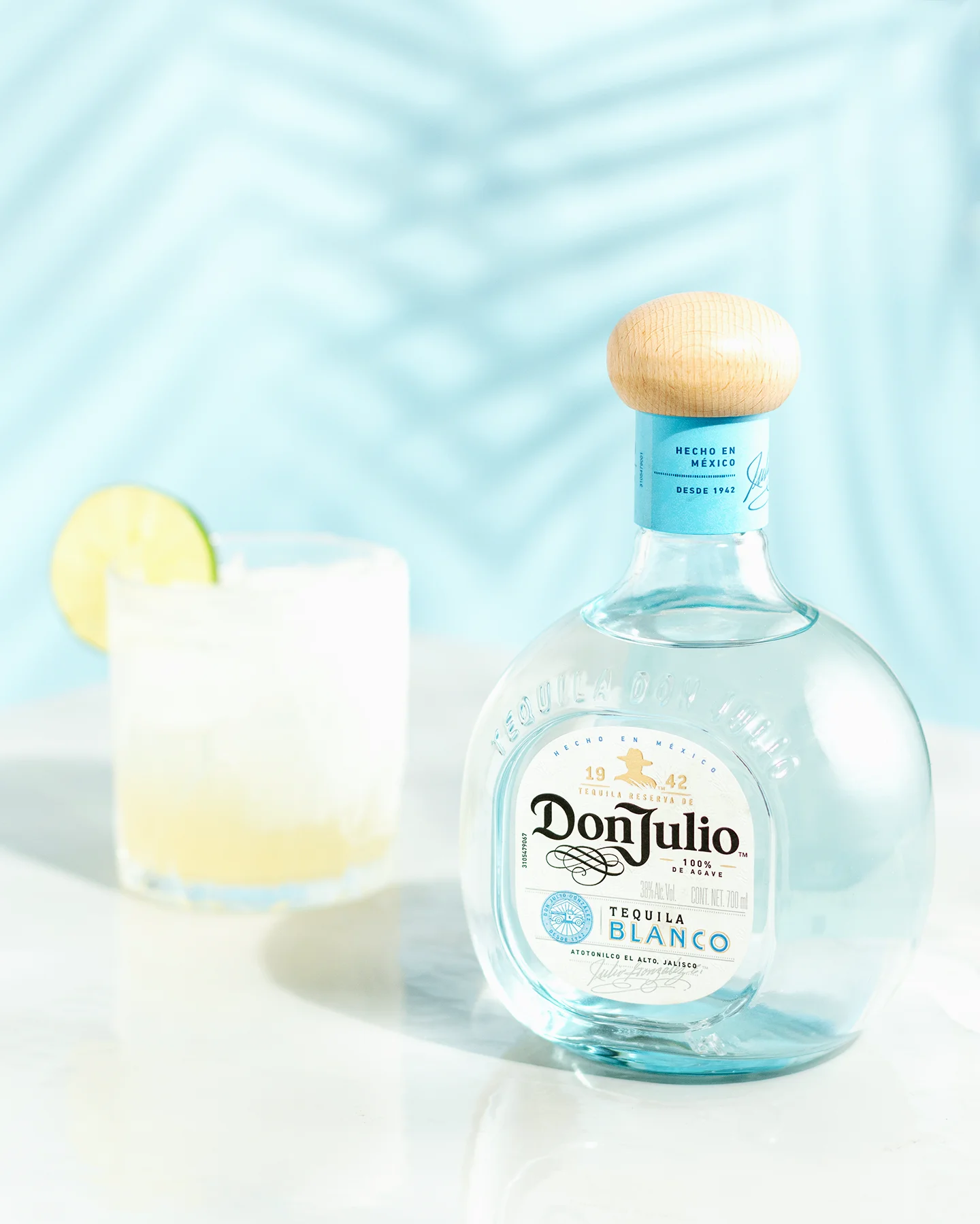 Fotografía publicitaria para marcas de tequila: botella Don Julio Blanco con trago preparado y sombras de palmera.